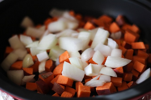 tagine full of sweet potatoes and onions, cooking.