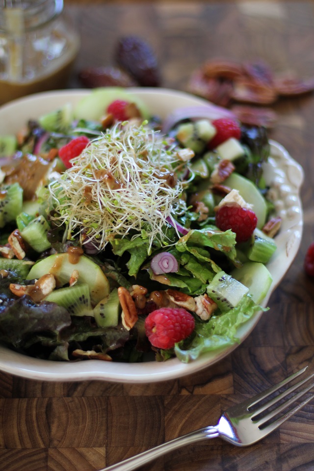 Spring Green Salad with kiwi, raspberries, cucumbers, sprouts, pecans, and date-balsamic vinaigrette | theroastedroot.net #vegetarian #recipe #healthy