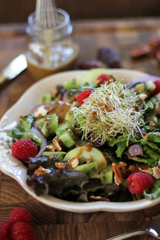 Spring Green Salad with kiwi, raspberries, cucumbers, sprouts, pecans, and date-balsamic vinaigrette | theroastedroot.net #vegetarian #recipe #healthy