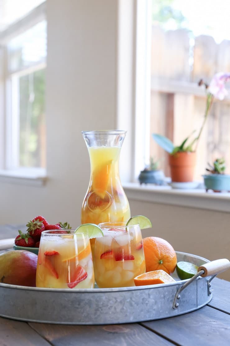 Two glasses and a pitcher of tropical white sangria