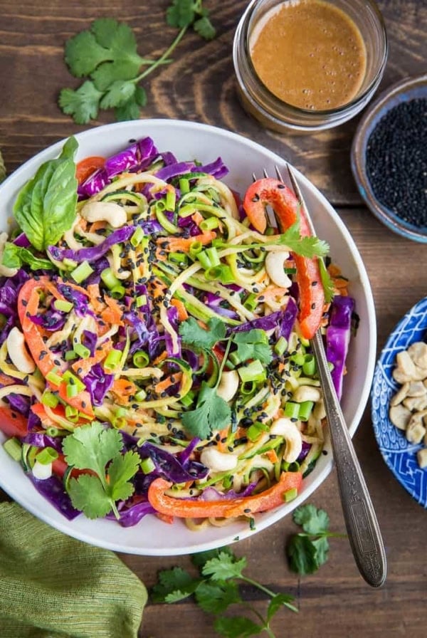 Bowl of zucchini noodles with fresh veggies and sauce.