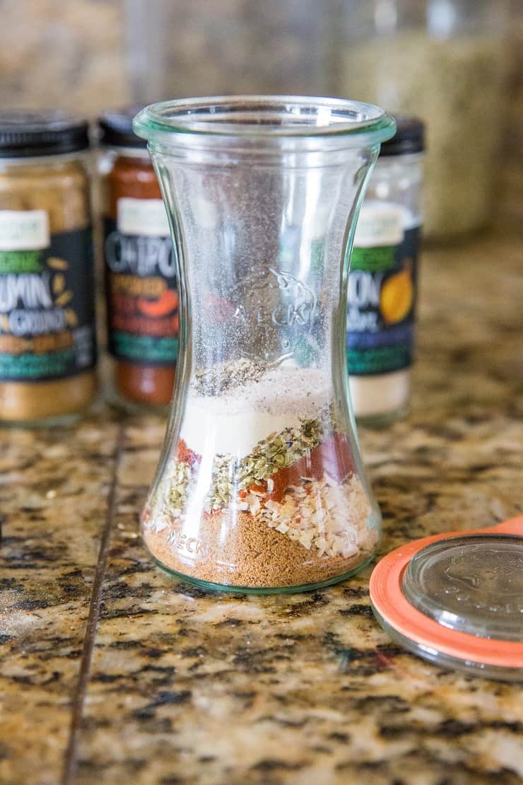 Jar of layers of seasonings to be mixed together for homemade taco seasoning.