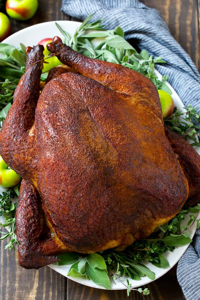 Smoked Turkey Recipe from Dinner at the Zoo- This smoked turkey recipe is a whole turkey thatโs coated in homemade spice rub then slow smoked to tender and juicy perfection. A super easy and impressive holiday main course that wonโt take up any oven space!