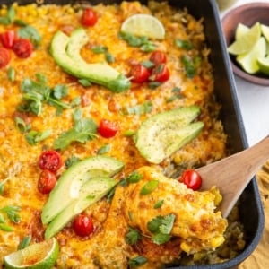 Wooden spoon scooping out some chicken and rice casserole
