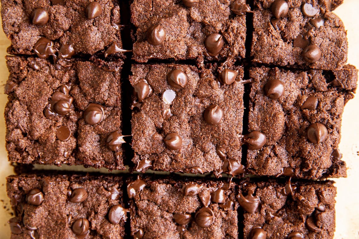 Nine gluten-free brownies cut into squares, viewed from above. The brownies are rich and fudgy with chocolate chips scattered on top, creating a textured and appetizing appearance.
