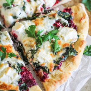 Four large slices of beet pesto pizza, fresh out of the oven.