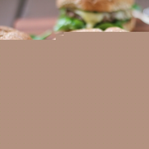 Lamb Burgers with kale and mint pesto on a cutting board, ready to eat.