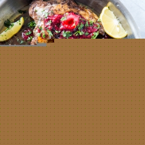 top down photo of balsamic raspberry jam chicken with raspberry jam to the side and sprigs of parsley