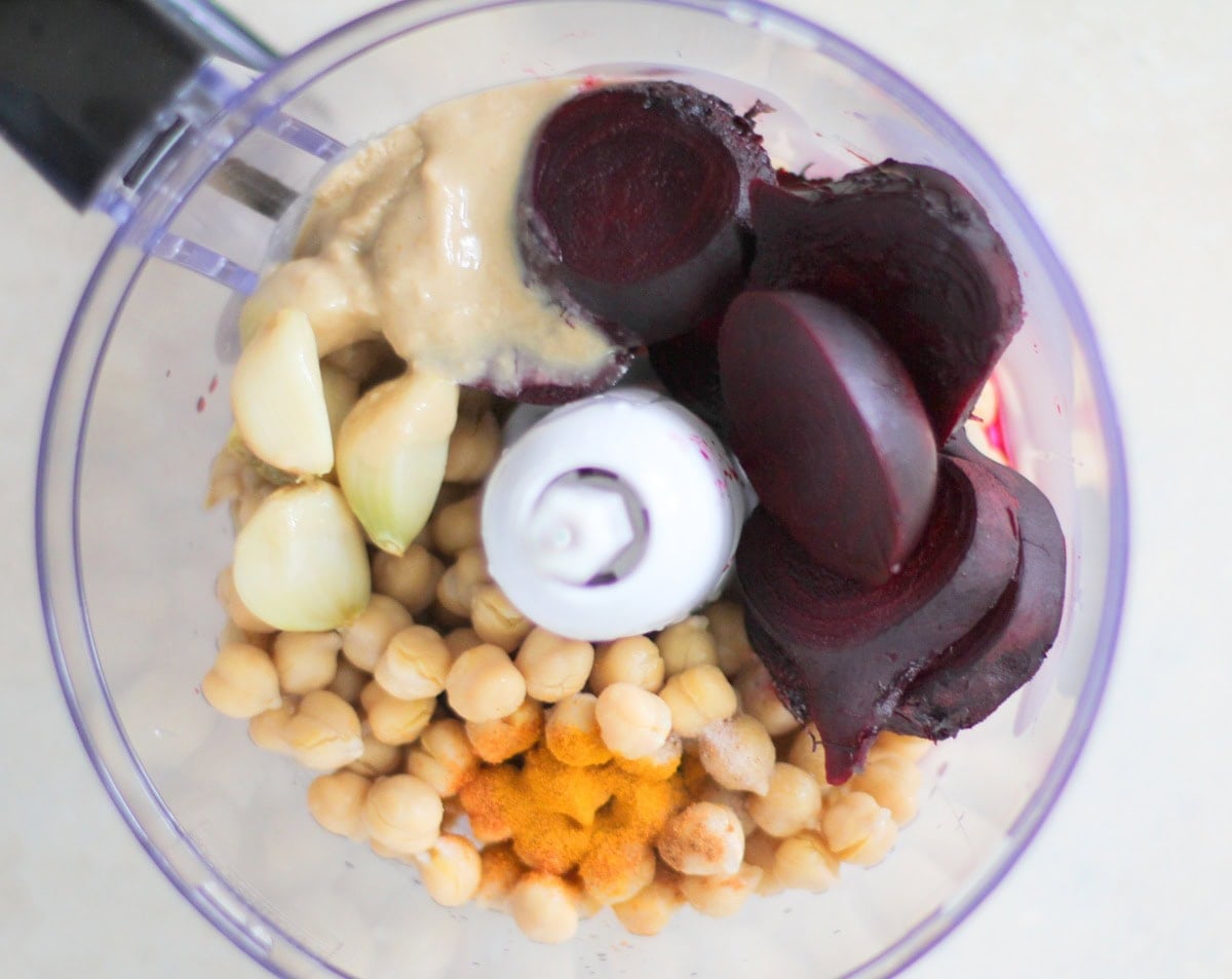 Ingredients for beet hummus in a food processor, ready to blend.