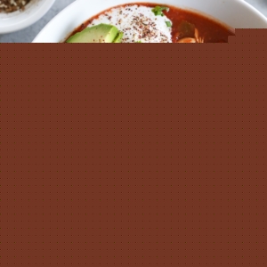 big bowl of chicken enchilada soup with avocado and sour cream
