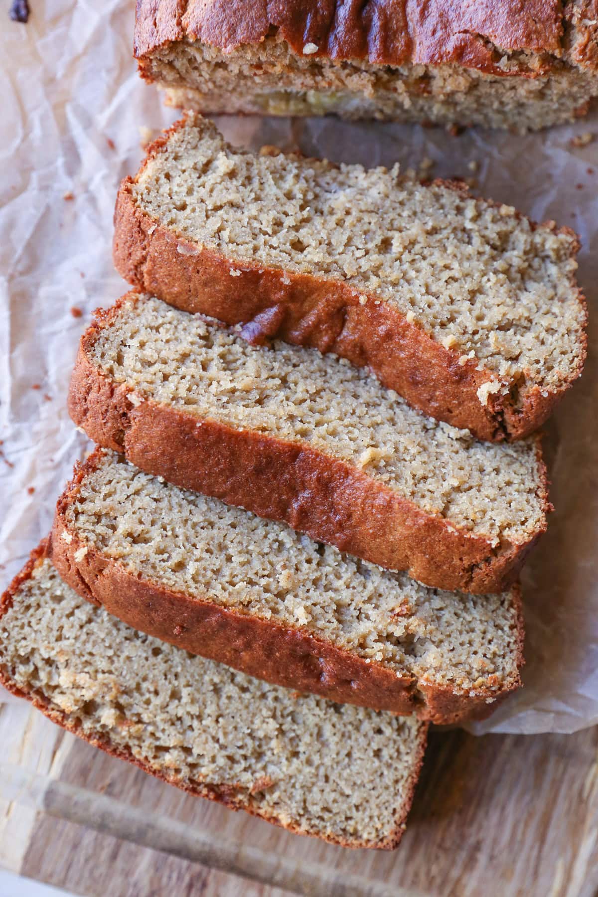 Grain-Free Almond Butter Banana Bread cut into slices on a wooden cutting board.