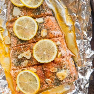Salmon Baked in Foil with garlic and lemon sitting on a baking sheet, ready to serve.