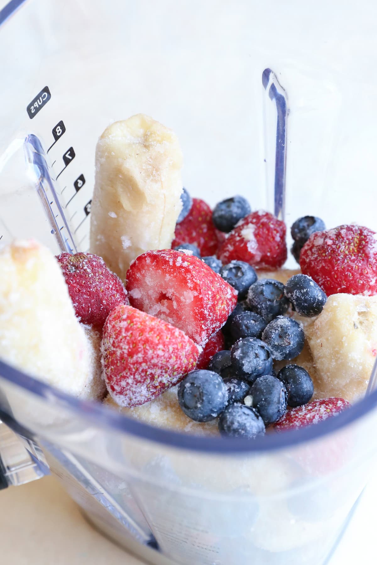 Blender full of frozen fruit to make nice cream.