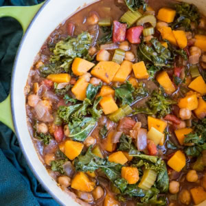 Butternut Squash and Chickpea Chili with Kale in a large pot with a blue napkin to the side, ready to serve.