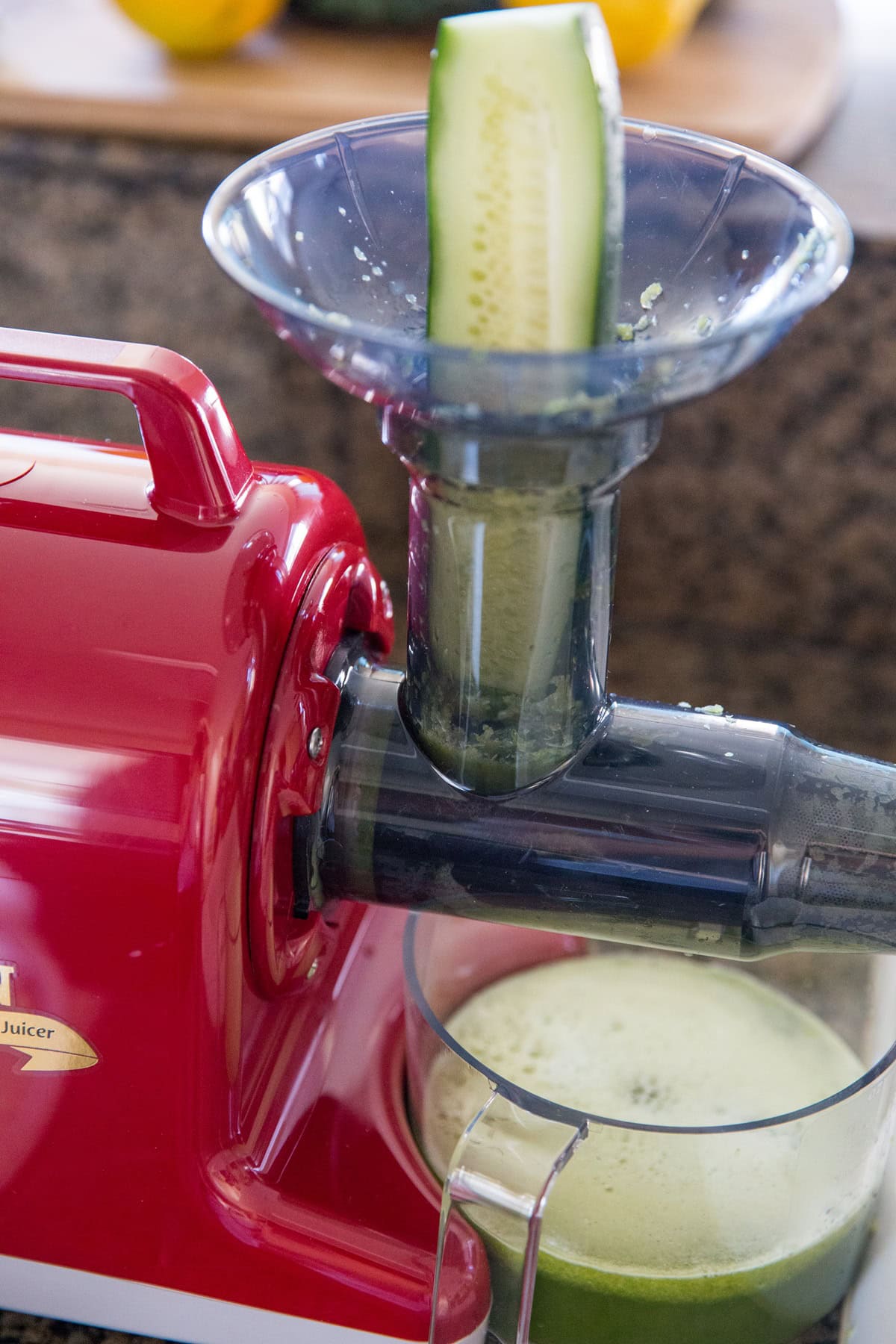 A juicer juicing a cucumber.