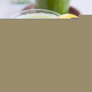 Two glasses of celery juice with slices of lemon.