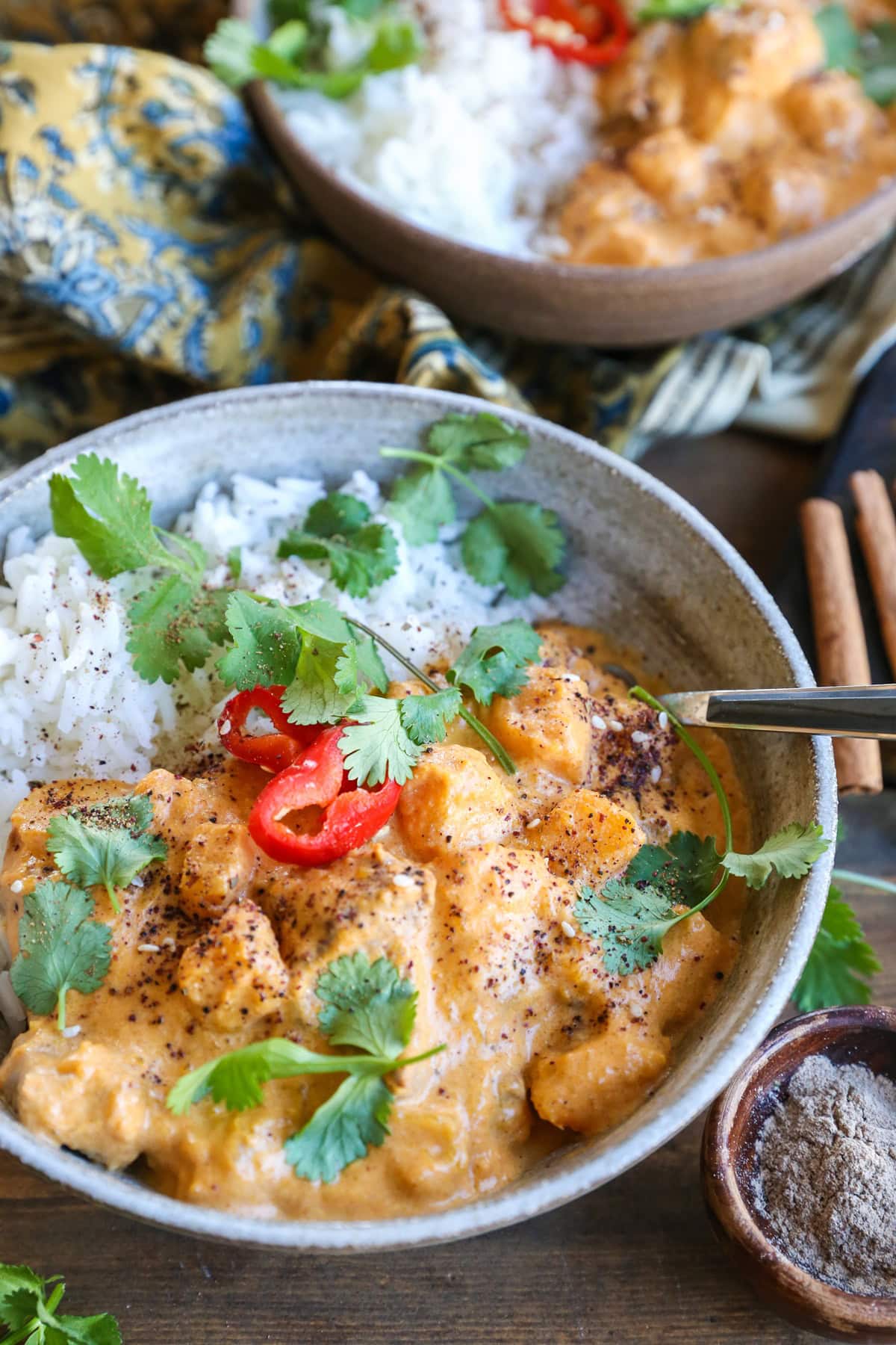 large ceramic bowl of chicken massaman curry with rice and cilantro.