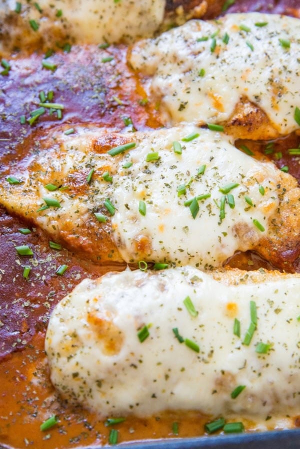 Cheesy baked chicken parmesan with mozzarella cheese and tomato sauce in a baking dish, fresh out of the oven.