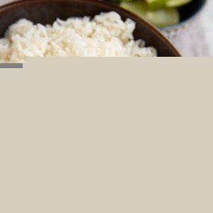Big bowl of coconut rice with chopsticks to the side and a fresh lime.