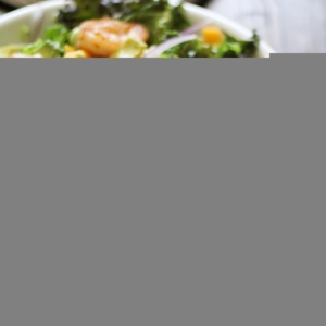 Shrimp salad in a large salad bowl with a fork to the side, ready to eat.
