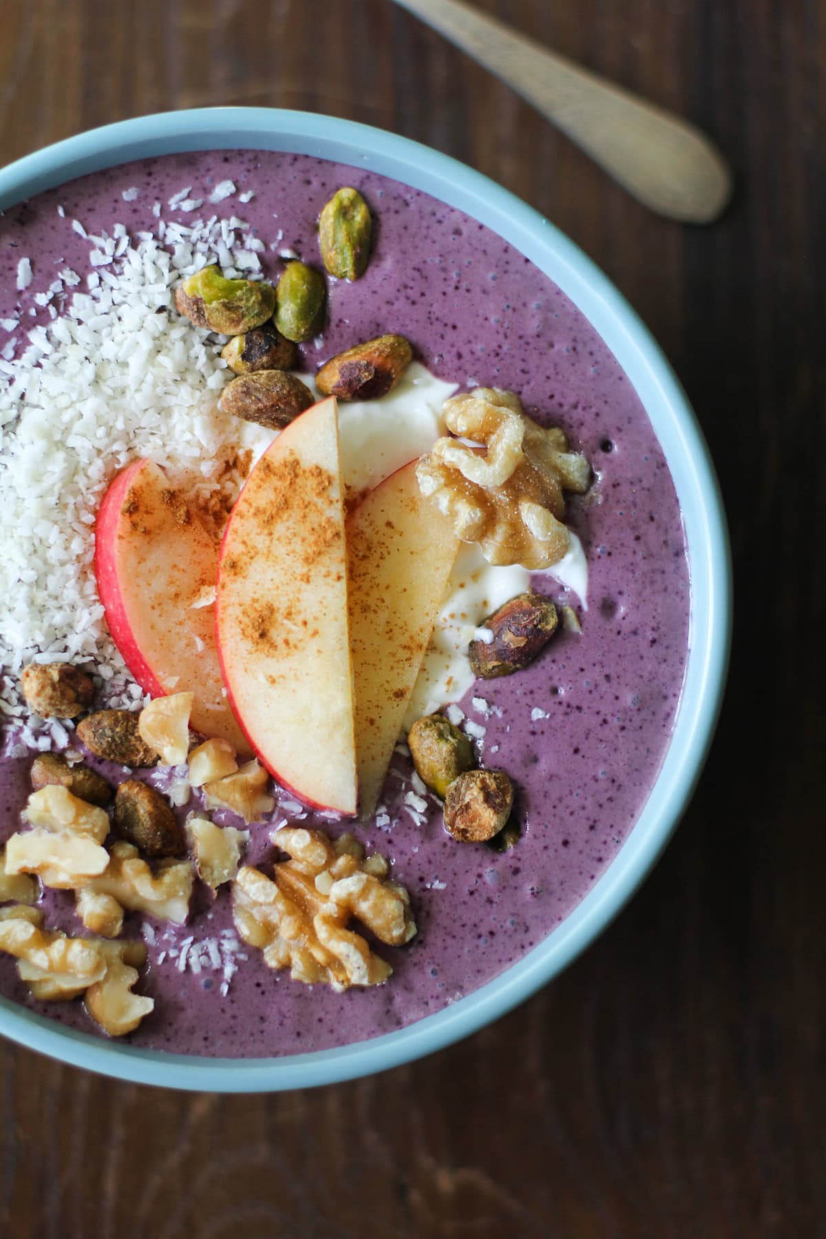 Blue bowl full of acai puree, fruit, and nuts