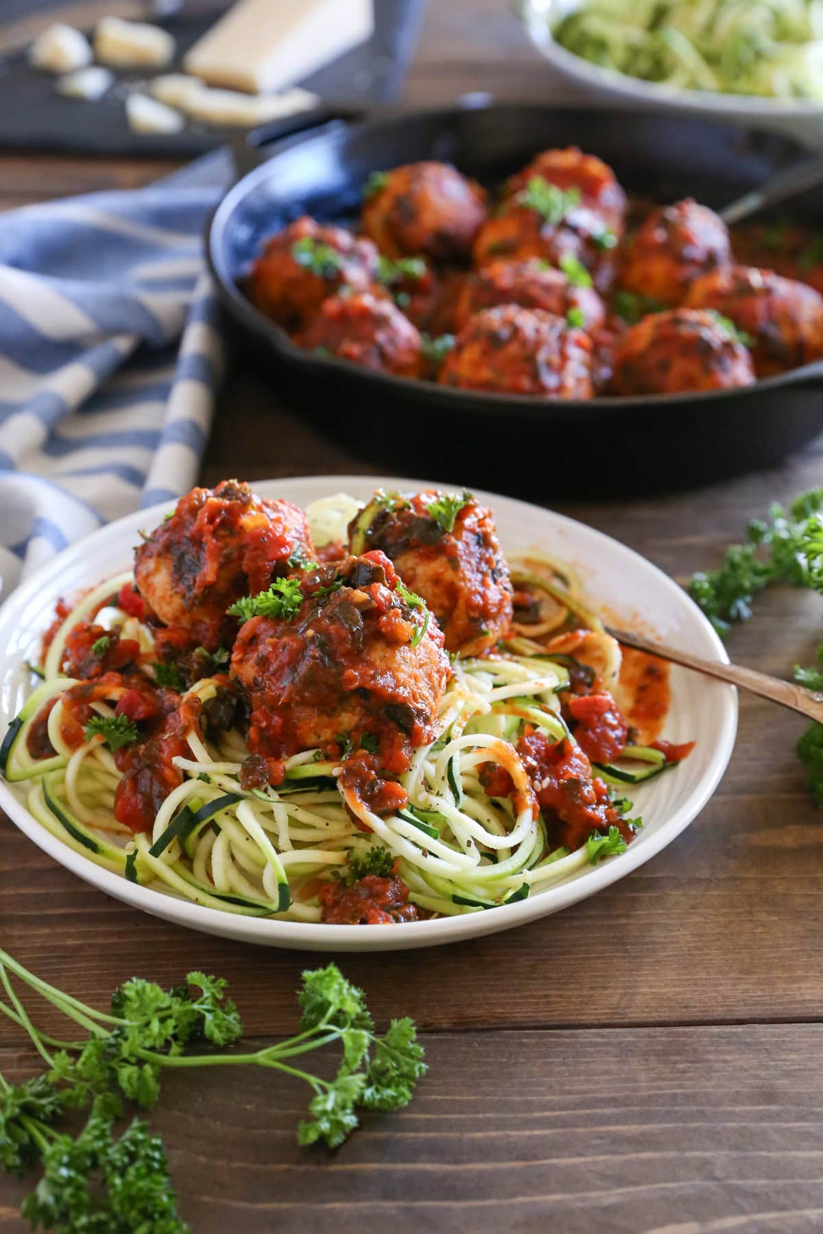 Plate of turkey meatballs with tomato sauce on top of zucchini noodles.