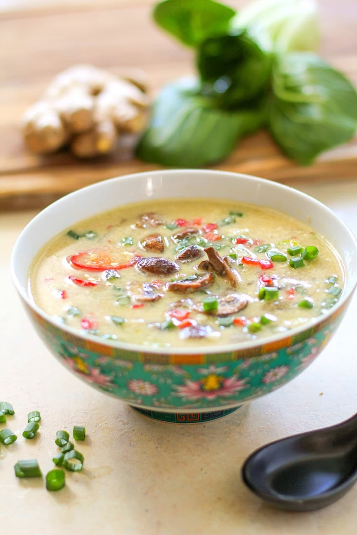 Large bowl of egg drop soup with chopped green onions and mushrooms on top.
