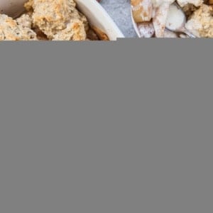 Casserole dish full of pear cobbler with an individual portion in a bowl.