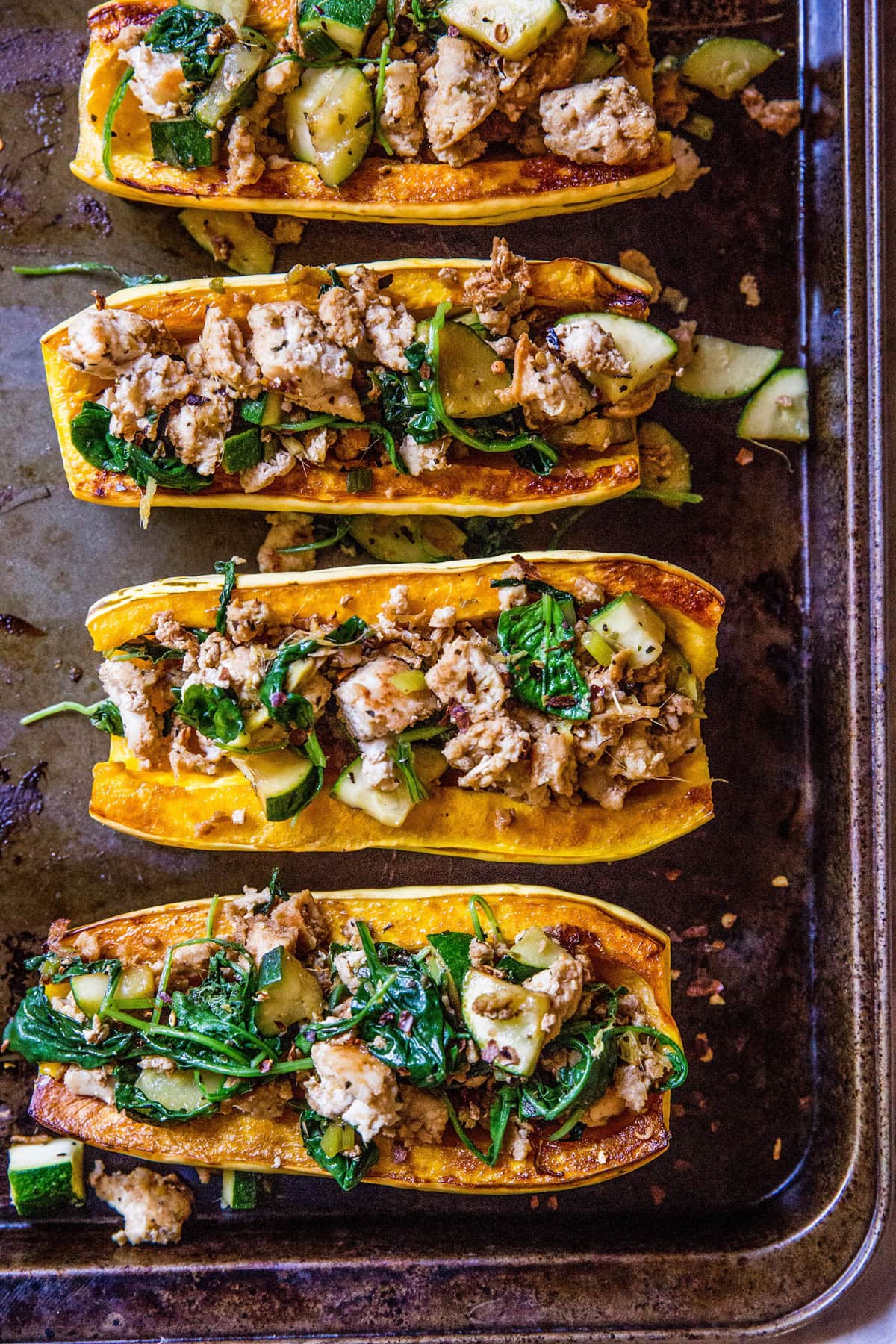 Baking sheet with turkey stuffed delicata squash with spinach