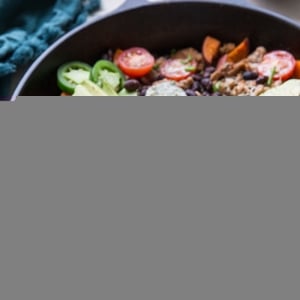 Cast iron skillet full of ground turkey, sweet potatoes, black beans, avocado, and more.