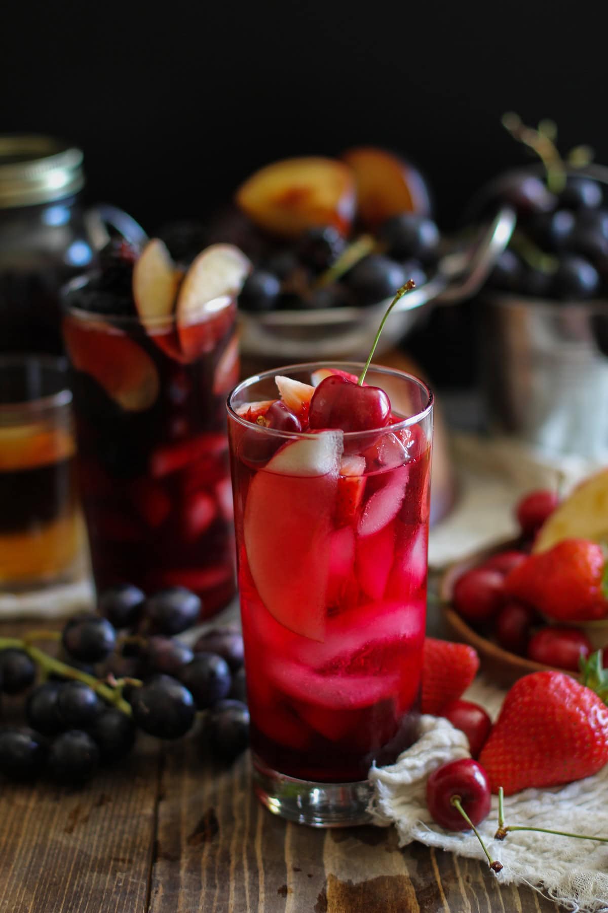 Two glasses of Halloween sangria. One is bright red, to mimic blood, and the other is black for a witch's brew.