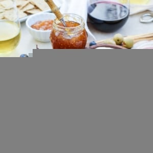 how to make a charcuterie board with meat, cheese, and wine. Large wooden board full of meats, cheeses, spreads, and fruit to create delicious bites of food.