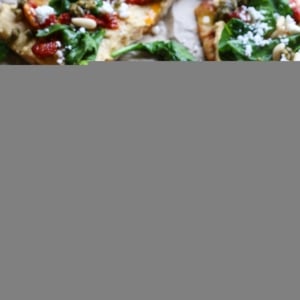 Black slate with flatbread smeared with hummus on top. Ready to eat