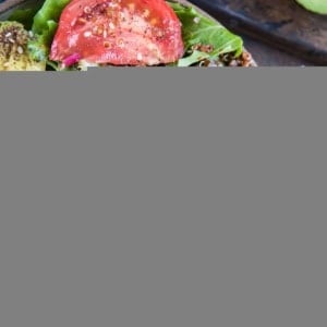 Big bowl full of barbacoa beef, greens, cabbage, tomatoes, quinoa, and avocado. Ready to eat.