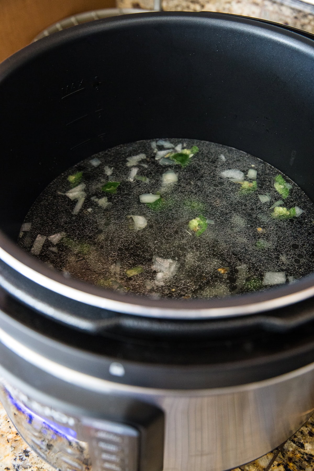 Pressure cooker full of ingredients for black beans.