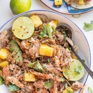 Pineapple Pork Carnitas in a blue-rimmed bowl - shredded pork made in the Instant pot with pineapple