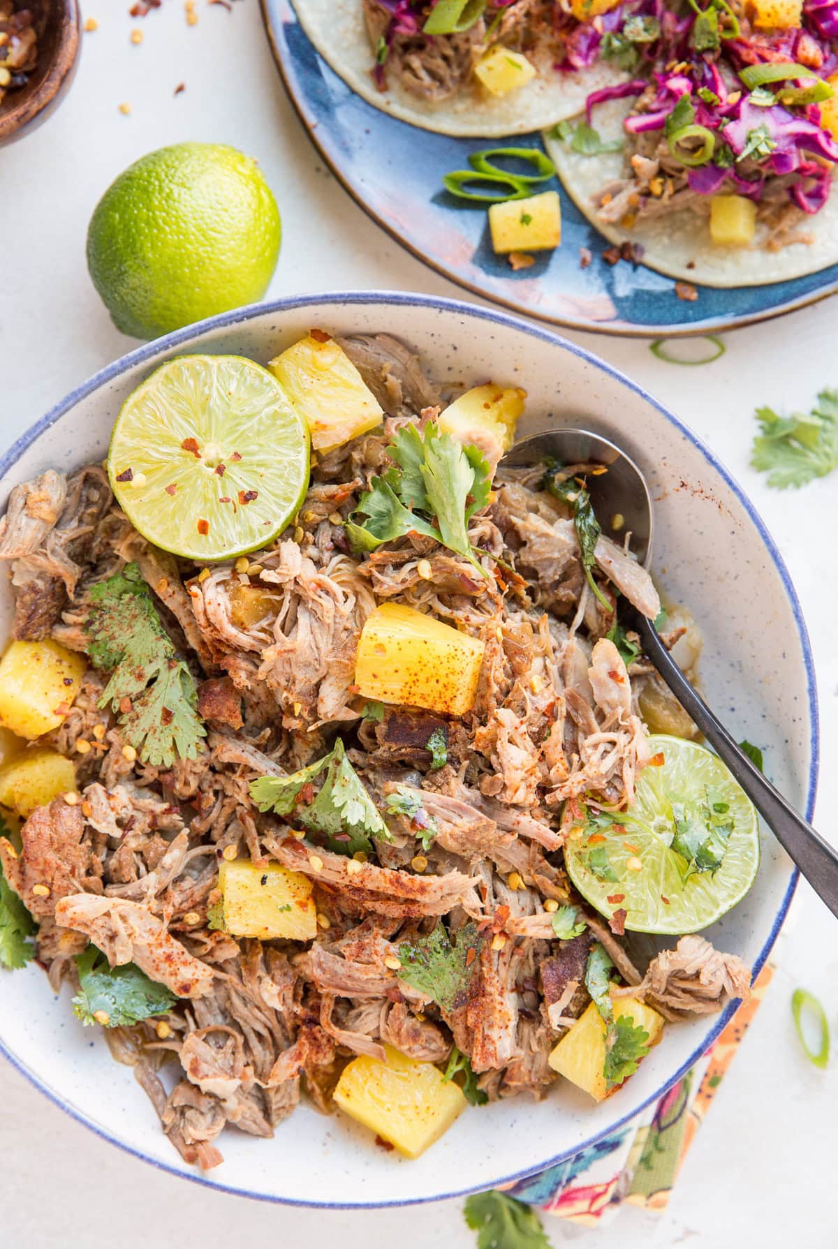 Pineapple Pork Carnitas in a blue-rimmed bowl - shredded pork made in the Instant pot with pineapple