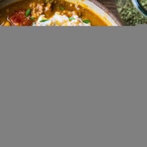 Large pottery bowl full of pumpkin chili with a spoon. Ready to serve.
