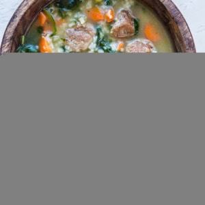 Two bowls of Italian Wedding Soup with rice. A red napkin and fresh parsley to the side.