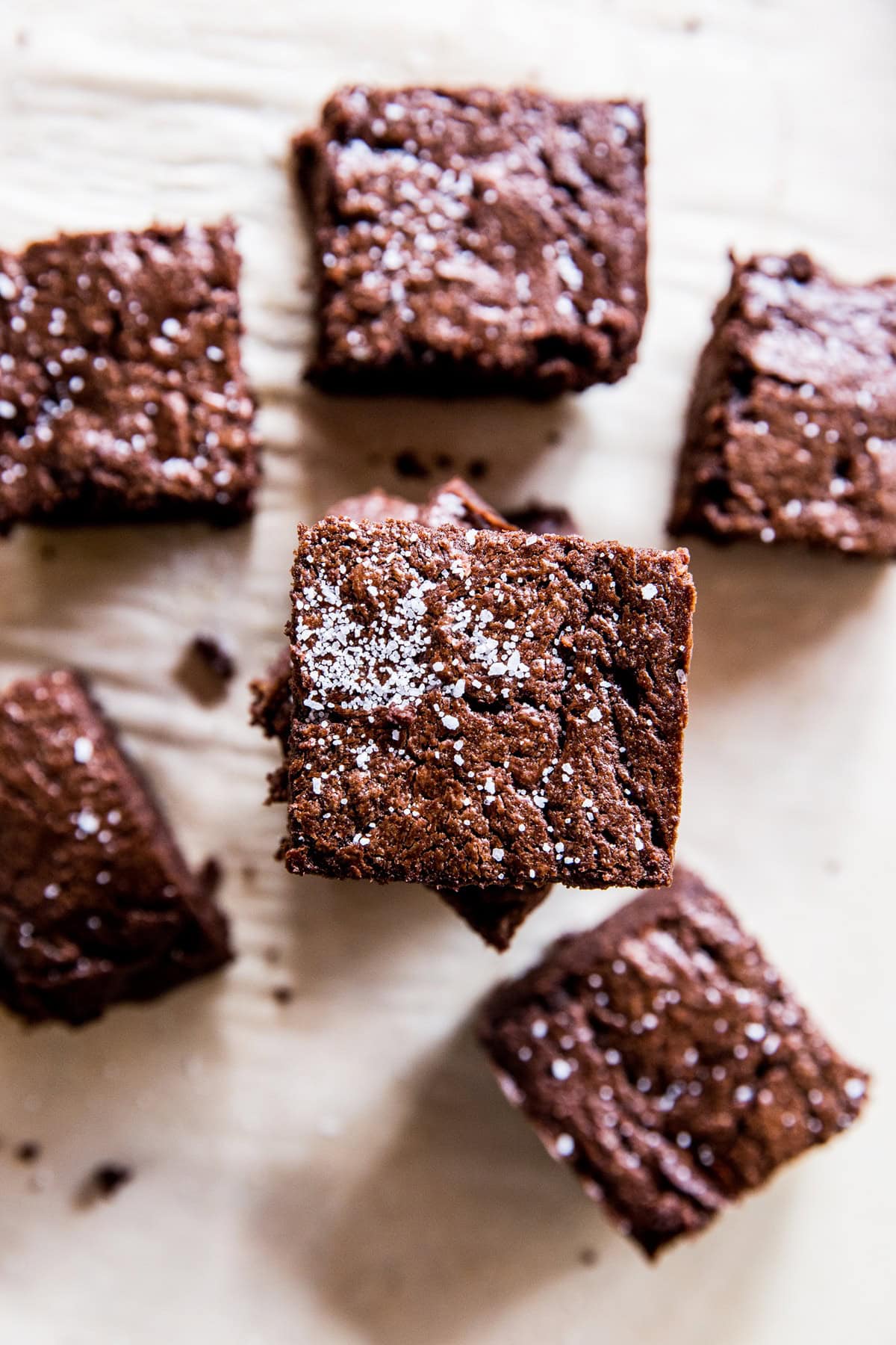 Keto brownies cut into squares and stacked on top of each other.