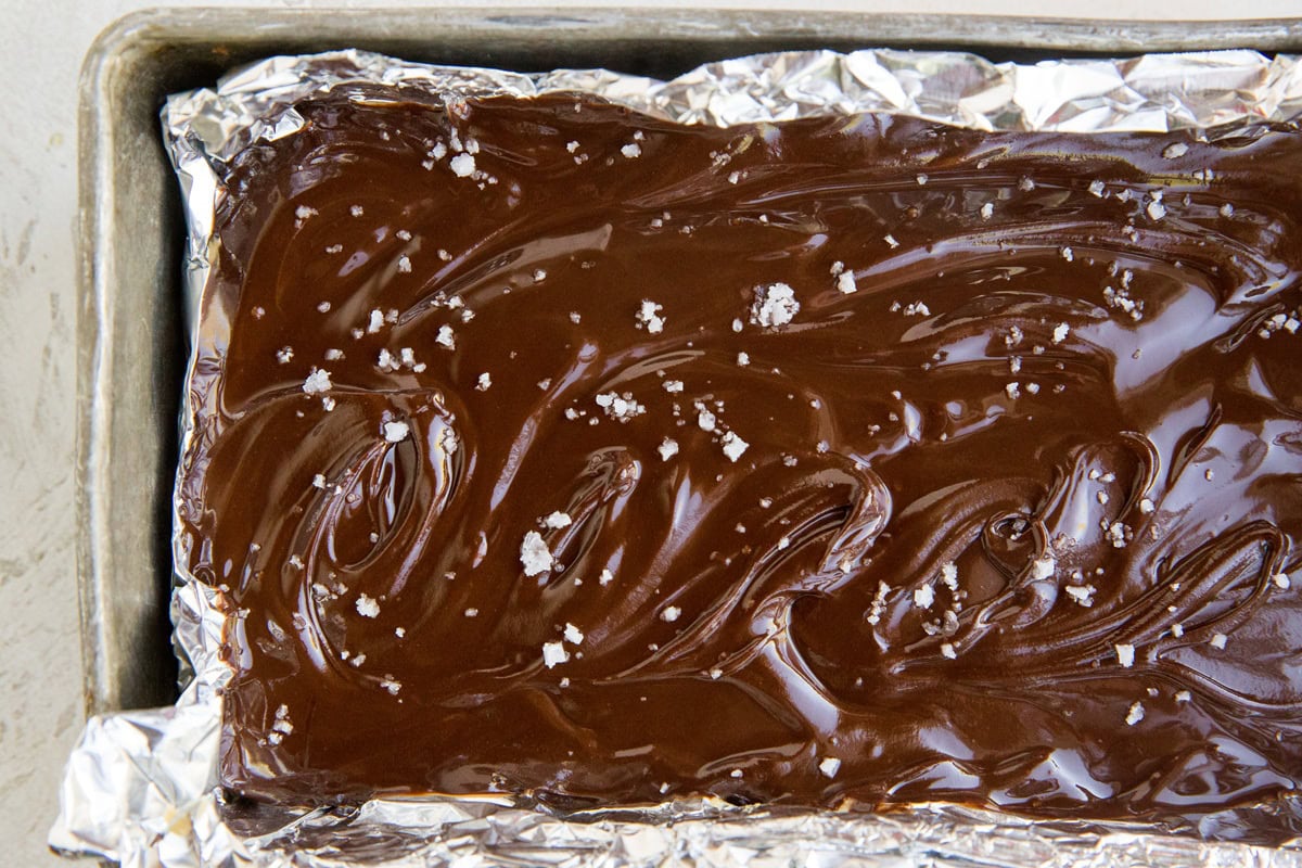 Finished chocolate peanut butter bars in a loaf pan sprinkled with sea salt, ready to go into the freezer.