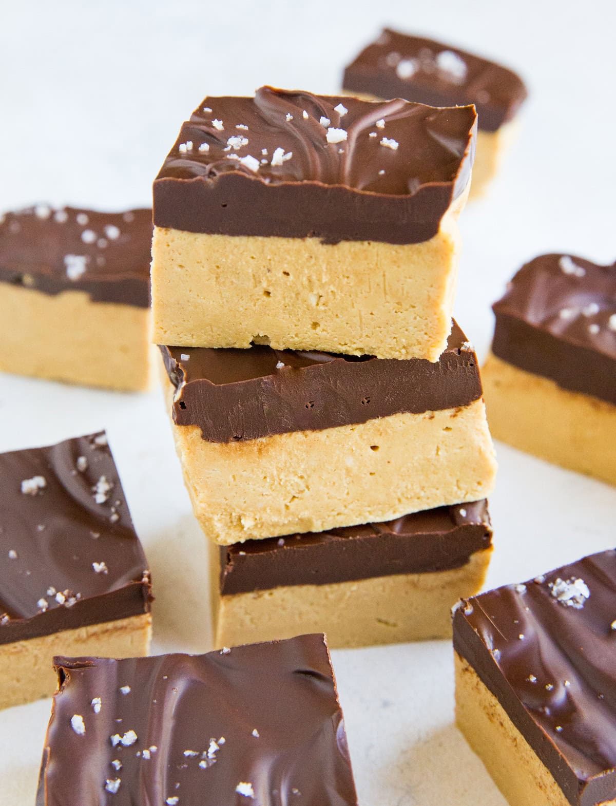 Stack of peanut butter bars with the rest of the bars all around. Ready to eat.