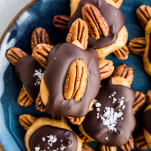 Blue plate full of pecan turtles. Sugar-free pecan turtle candy.