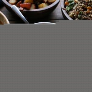Big white bowl full of mashed kabocha squash with side dishes all around on a holiday table.