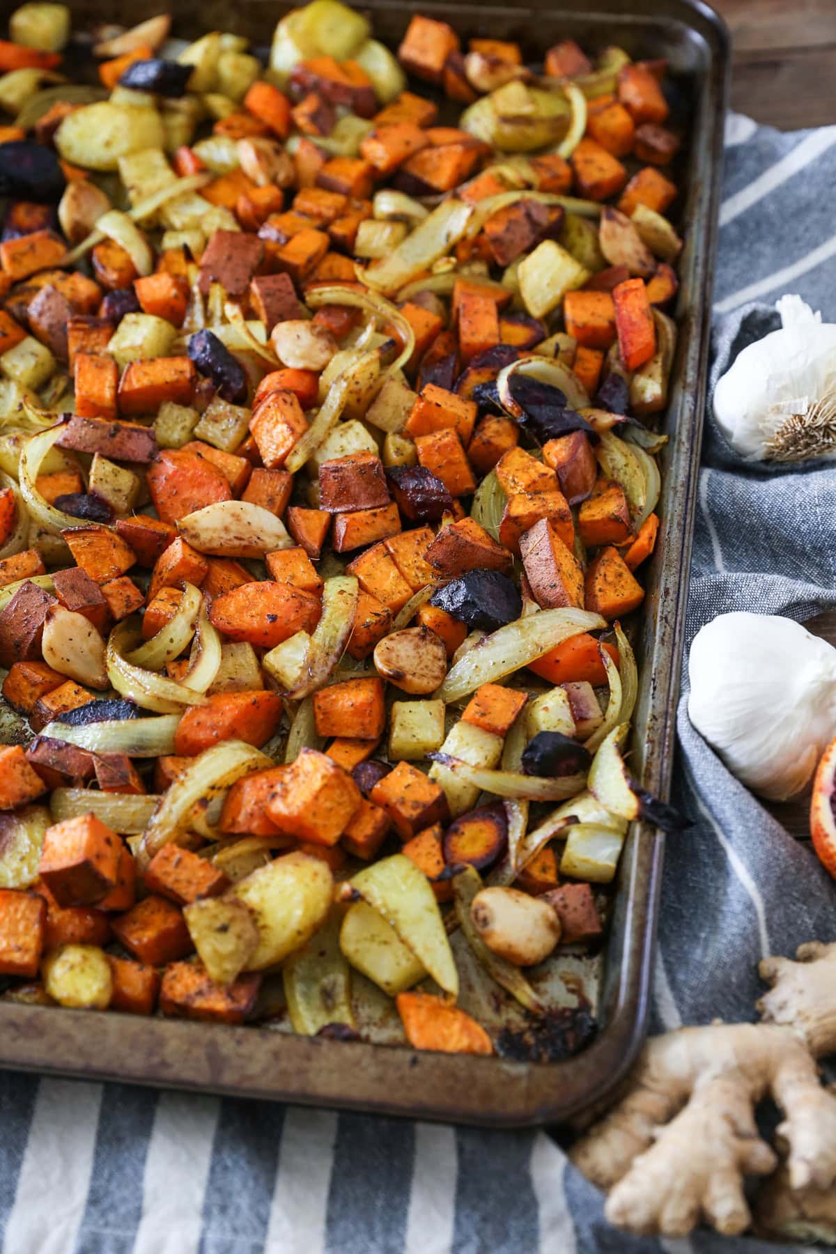 Baking sheet with roasted vegetables spread over the full surface. Fresh out of the oven and ready to serve.
