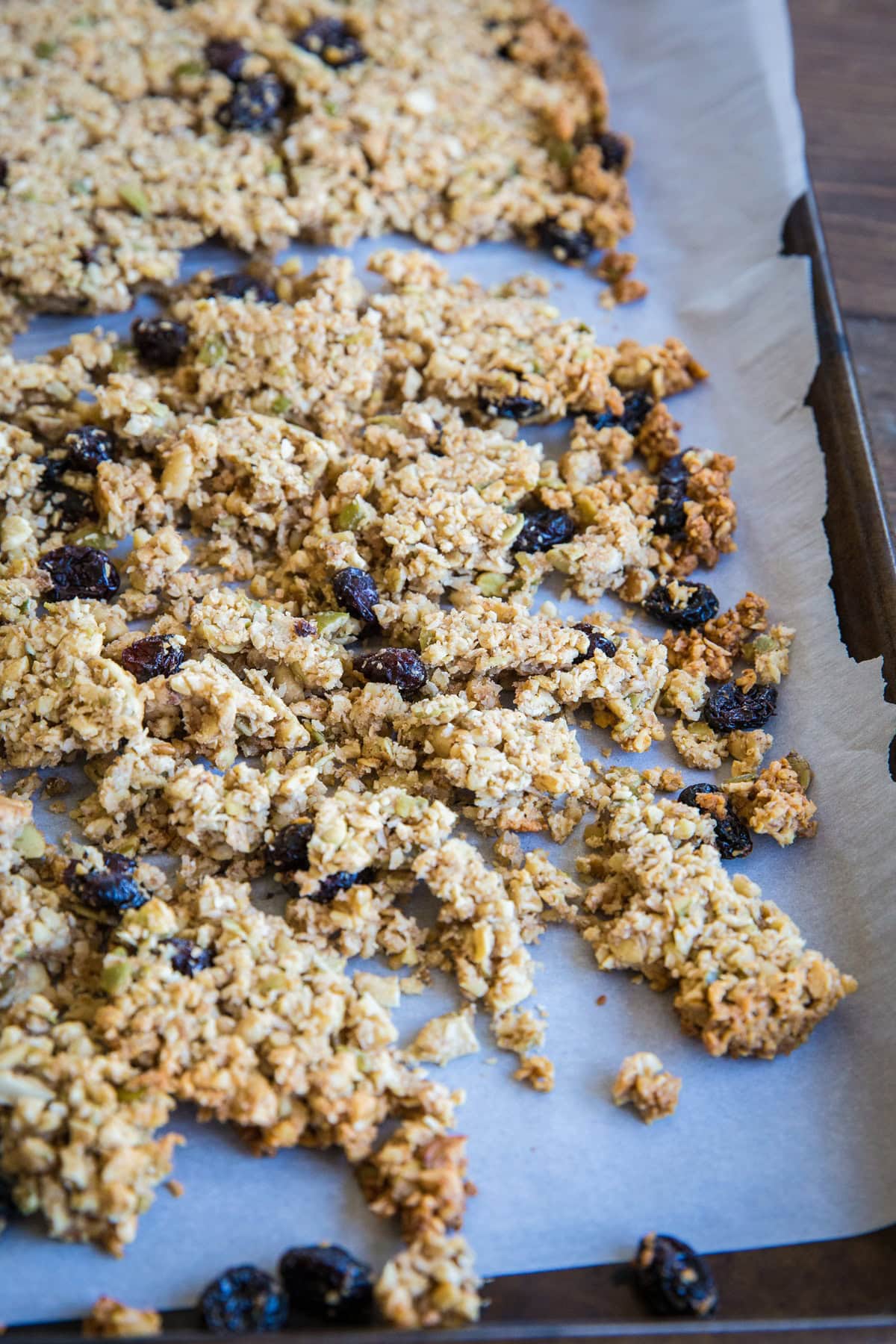 Baking sheet of paleo granola fresh out of the oven and broken into large chunks for big granola clusters.