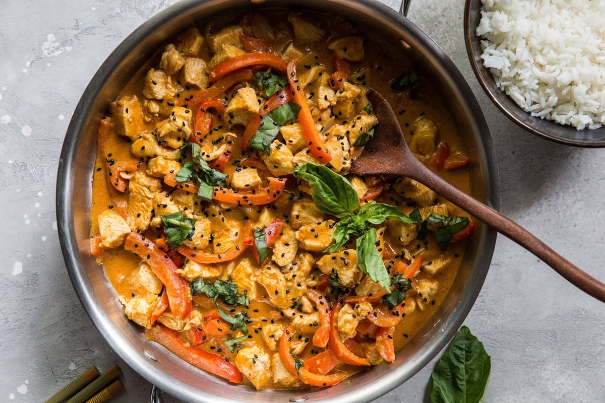 Skillet of panang curry with chicken, basil, bell peppers, and a creamy curry sauce. Ready to serve.