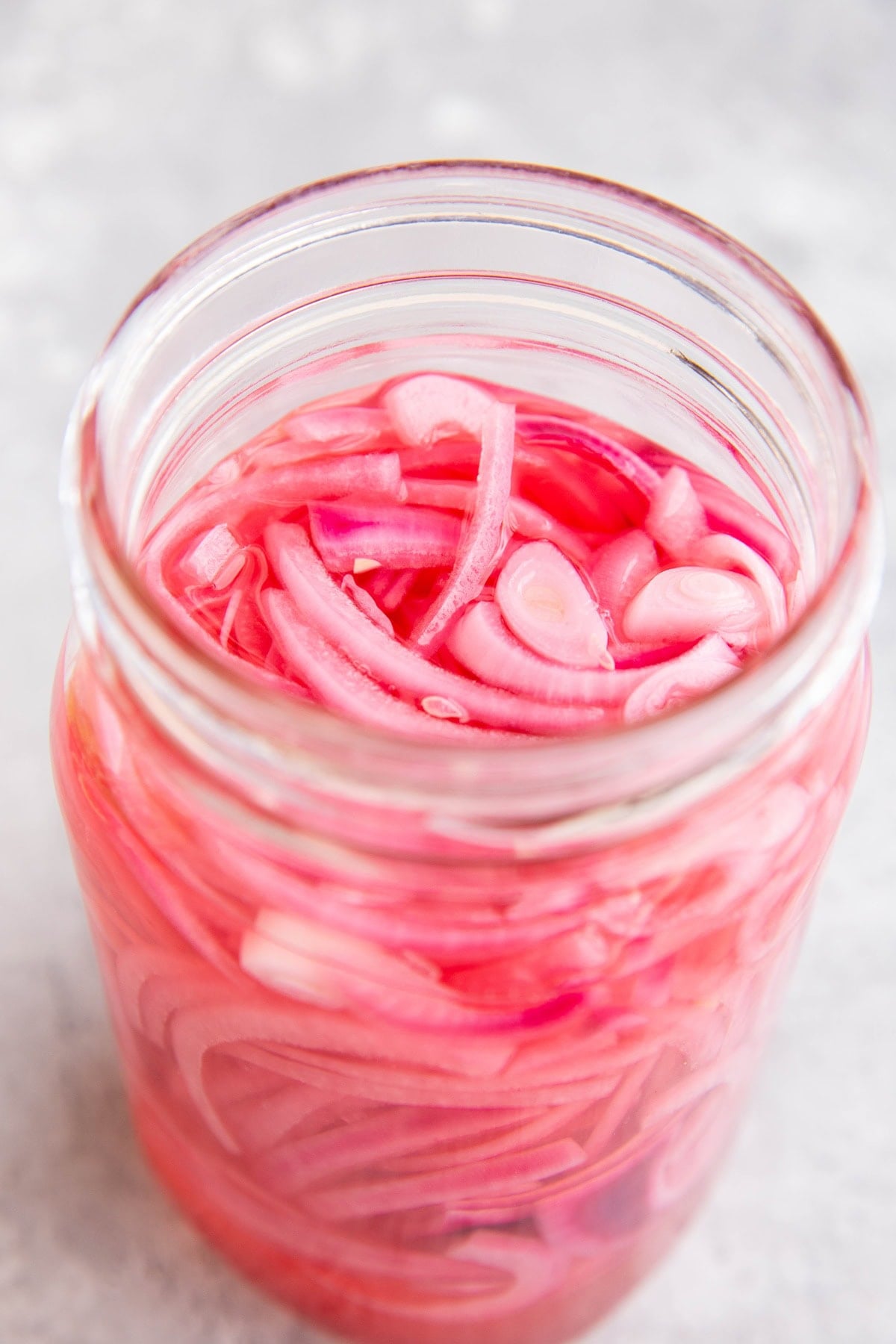 large jar of pickled red onions, ready to eat.