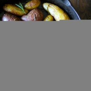 Rosemary Roasted Fingerling Potatoes in a cast iron skillet with fresh rosemary all around.