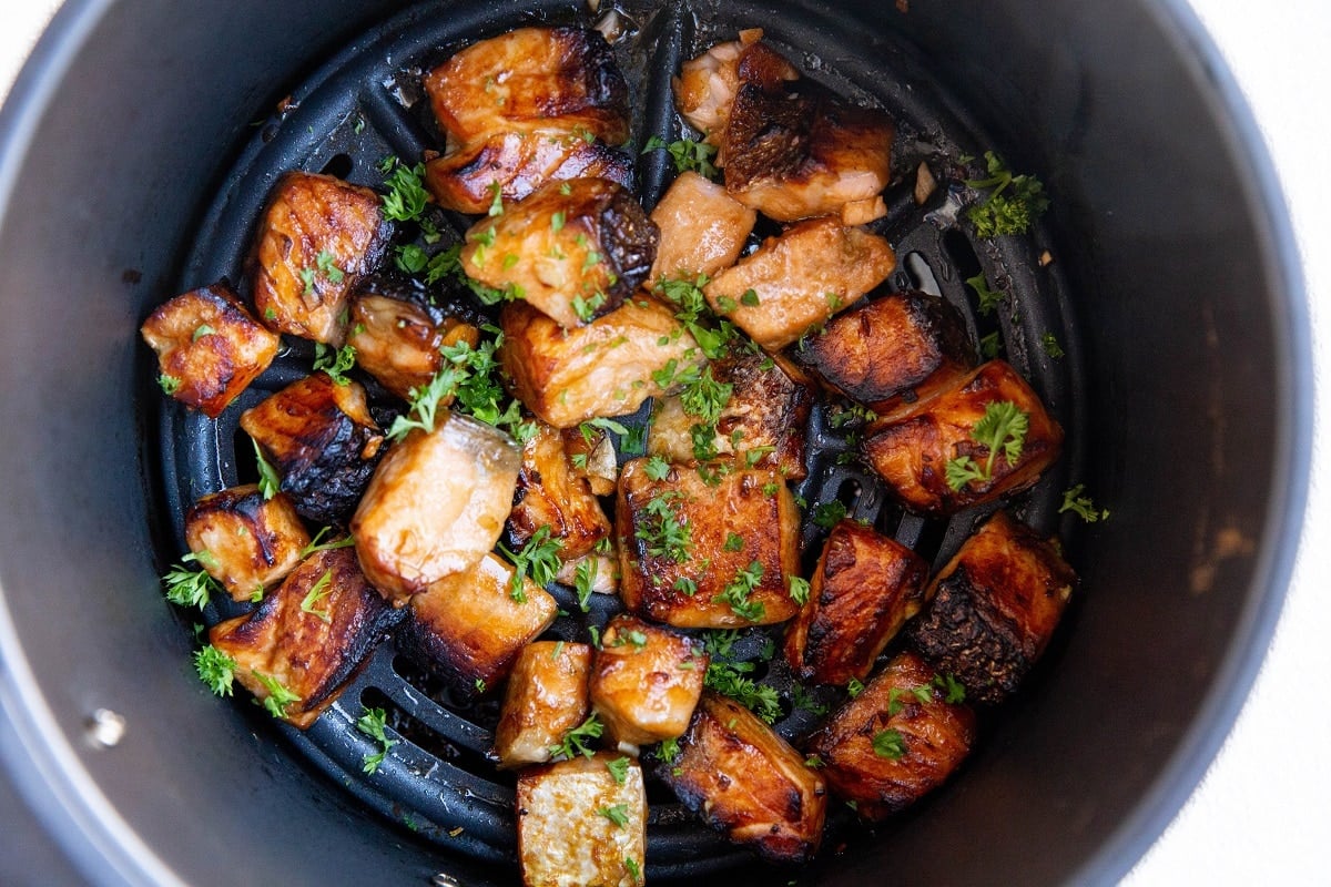 Air fryer salmon bites freshly cooked in the air fryer basket.